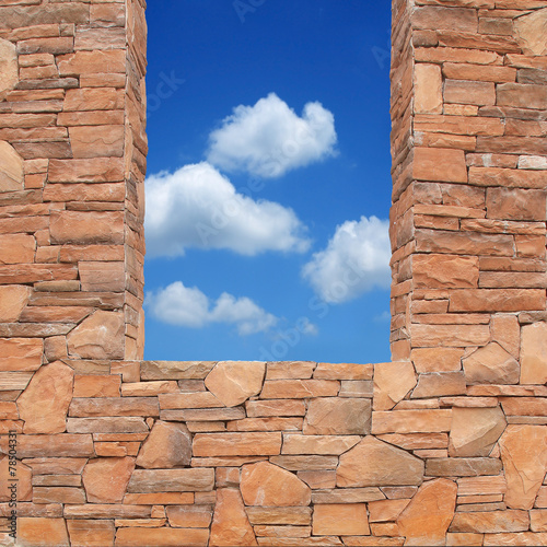 grunge stone wall with hole of blue sky