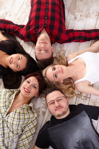 group of young people lying on the floor in a circle together