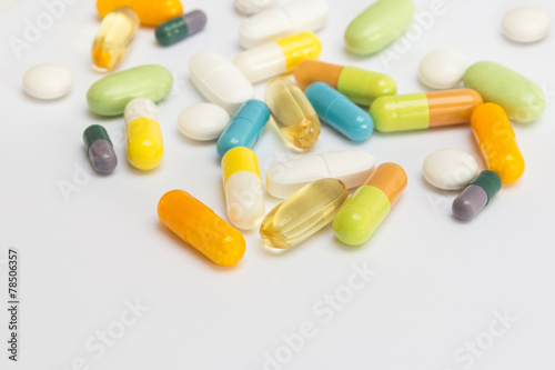 Many colored pills / tablets / capsules on white background