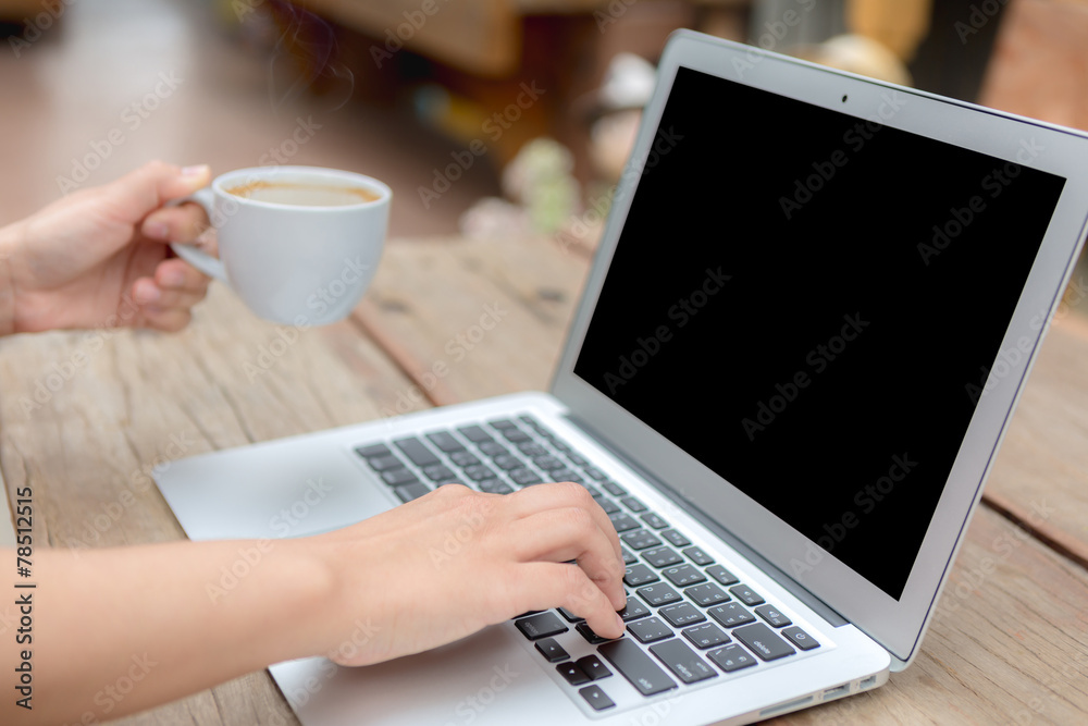 Fototapeta premium Closeup of business woman hand typing on laptop keyboard and cof