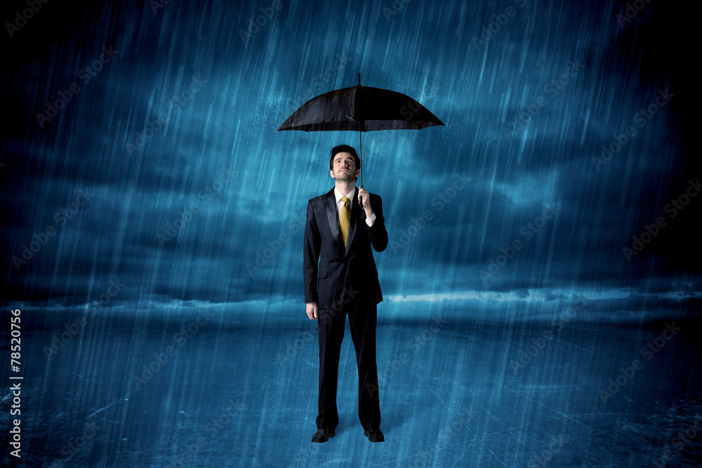 Business man standing in rain with an umbrella Business man standing in rain with an umbrella