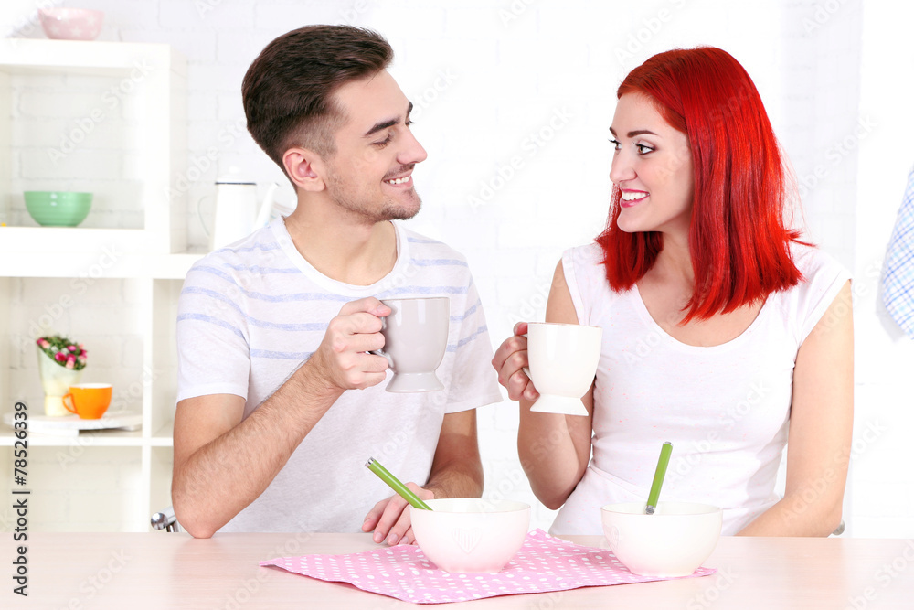 Happy couple has breakfast in kitchen