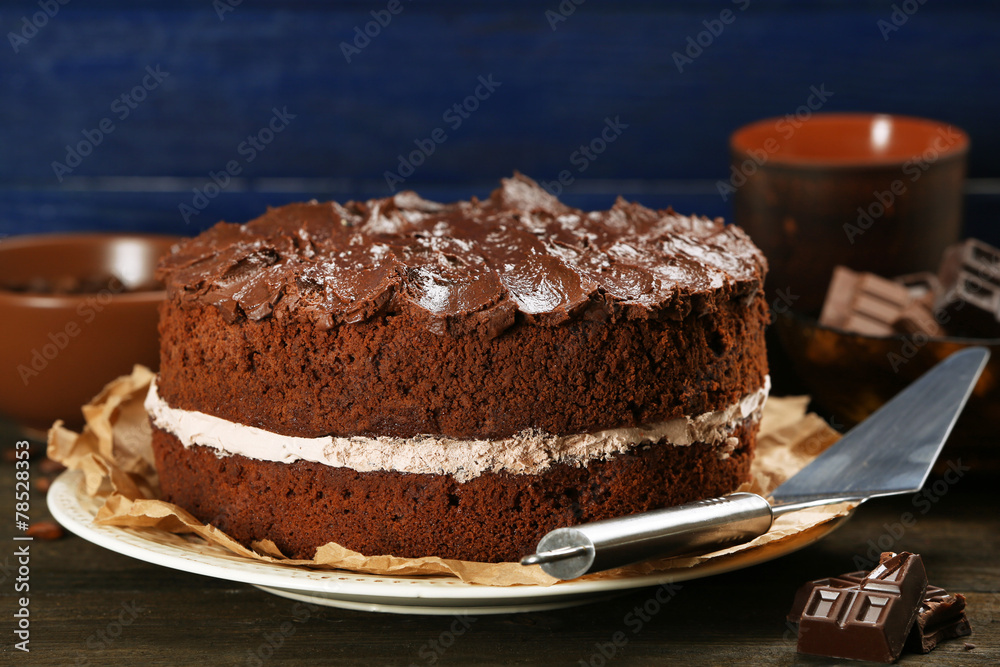 Delicious chocolate cake on table on blue background Delicious chocolate cake on table on blue background