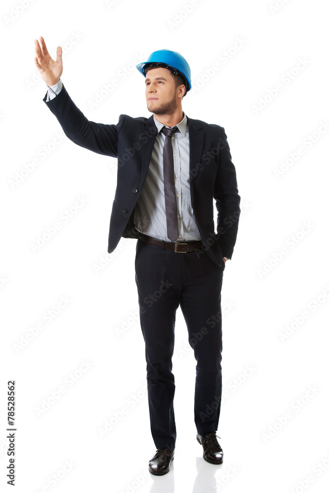 Businessman in hard hat showing copyspace. Businessman in hard hat showing copyspace.