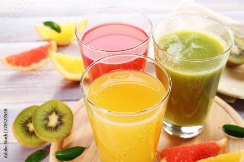 Billede på lærred Fresh juices with fruits on wooden table