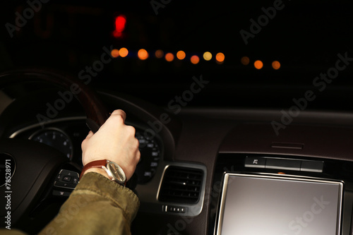 Man driving his modern car at night in city, close-up © Africa Studio