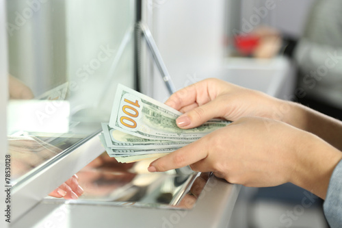 Female hand with money in cash department window. Currency