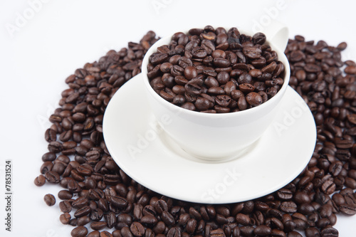 Roasted coffee beans with a cup