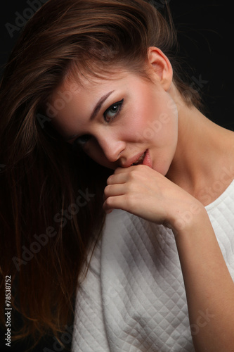 Portrait of beautiful young woman face. Isolated on dark