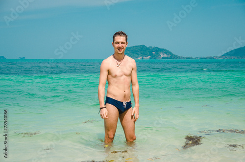 Handsome young man posing and stand at the tropical sea