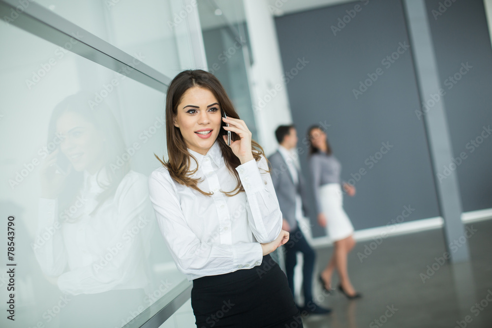 Young woman in office with mobile phone Young woman in office with mobile phone