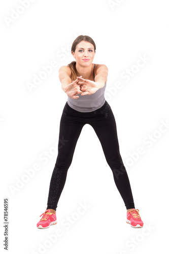 Young sporty woman stretching arms front
