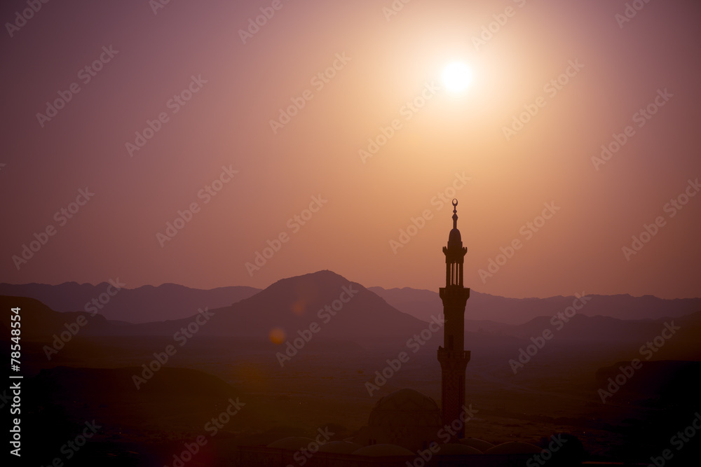 Sunset over desert with muslim mosque