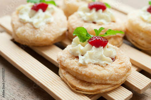 Strawberry Tart with Fresh Cream in Puff Pastry on wooden backgr