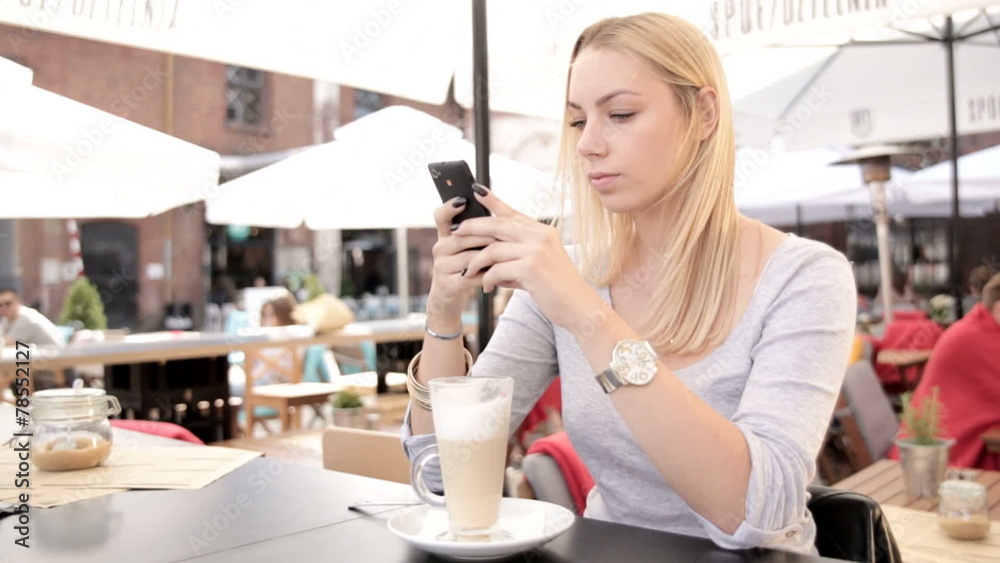 Beautiful blond woman with smartphone in cafeteria.FULL HD Beautiful blond woman with smartphone in cafeteria.FULL HD