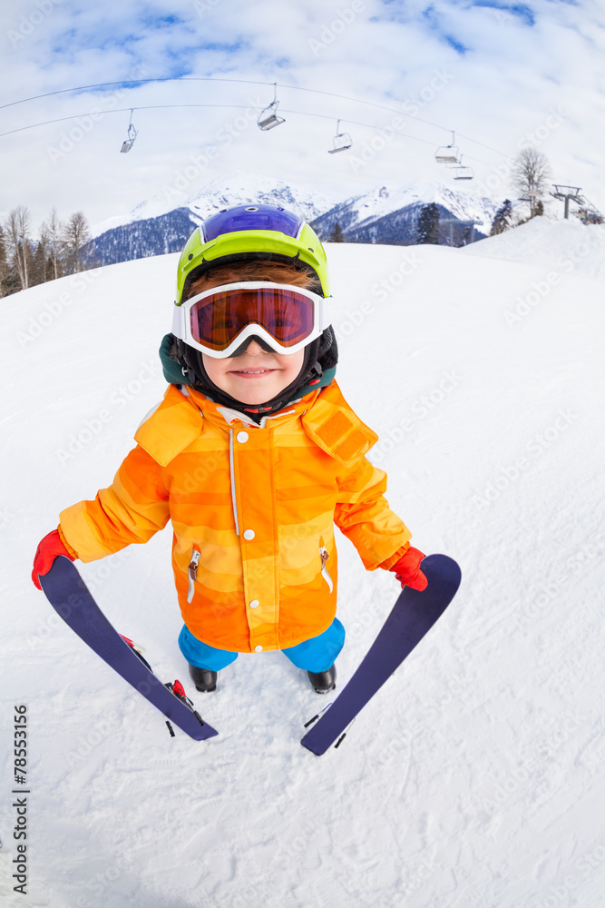 © Sergey Novikov - Smiling boy wearing mask holds ski in mountains