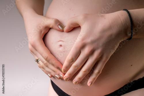 Wallpaper Mural Pregnant Woman holding her hands in a heart shape on her baby bu Torontodigital.ca