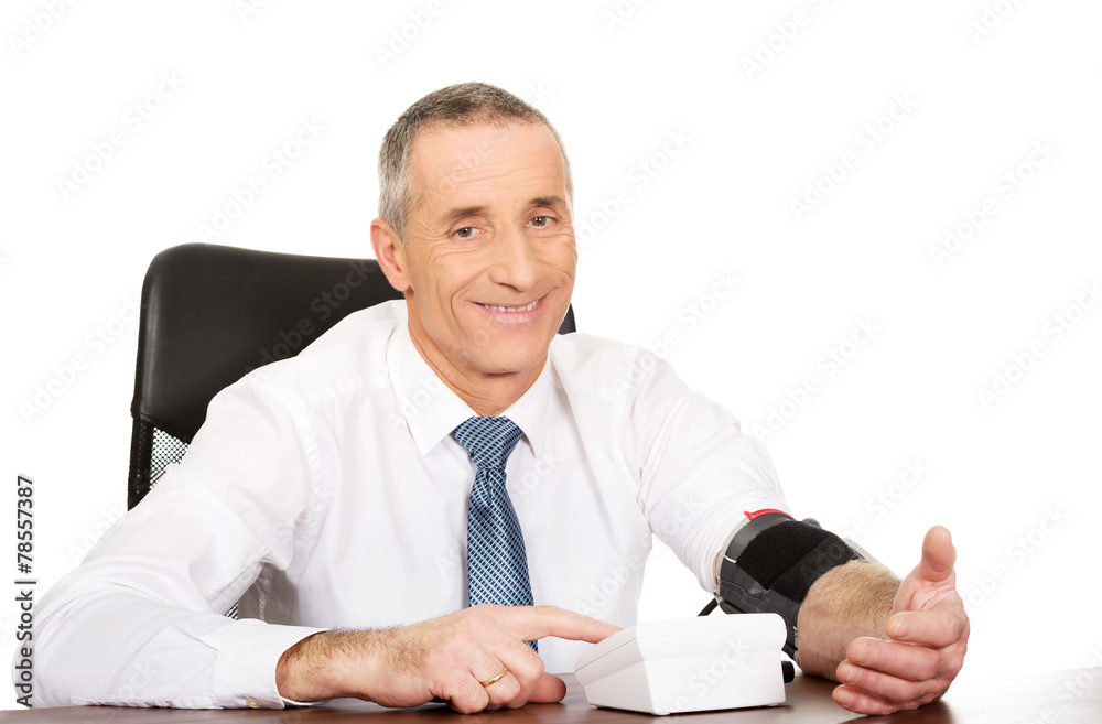 Mature businessman measuring blood pressure Mature businessman measuring blood pressure