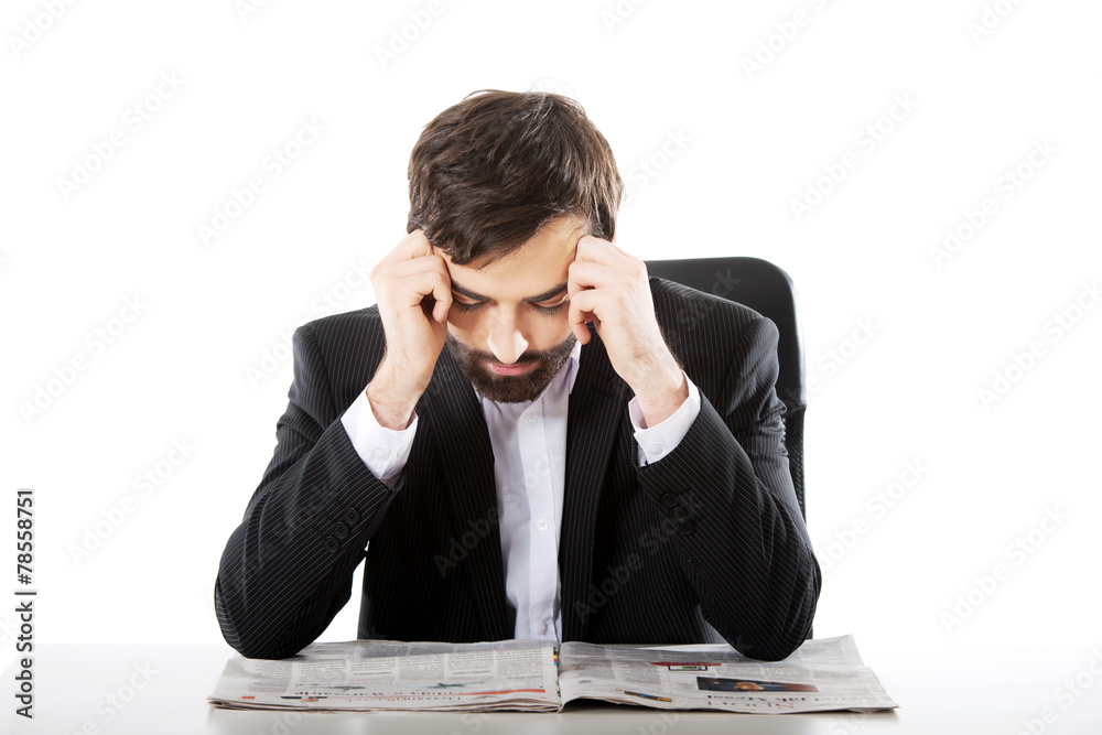 Young man reading newspaper in the office. Young man reading newspaper in the office.