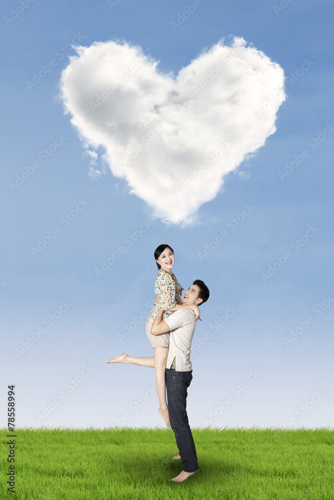Couple having fun under heart shaped cloud Couple having fun under heart shaped cloud