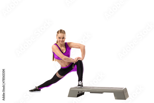 Fototapeta Naklejka Na Ścianę i Meble -  Grinning girl doing shaping exercise on stepper