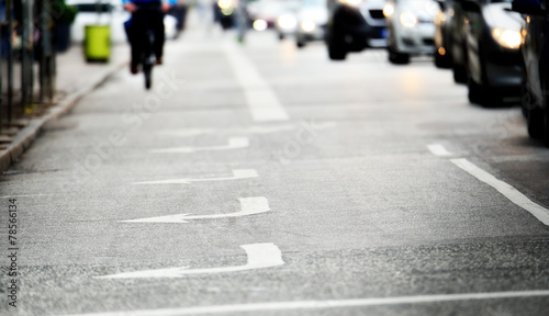 Gloomy road with arrows, bicylist distant © connel_design