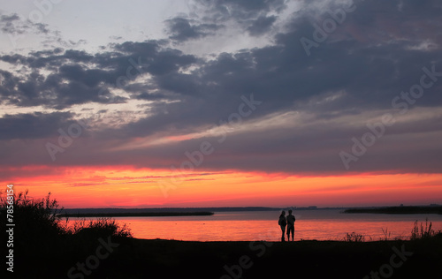 Couple at Beach on Sunset Background