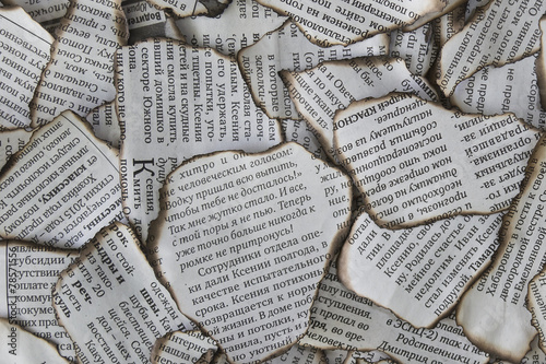 Burnt scraps of newspaper for background