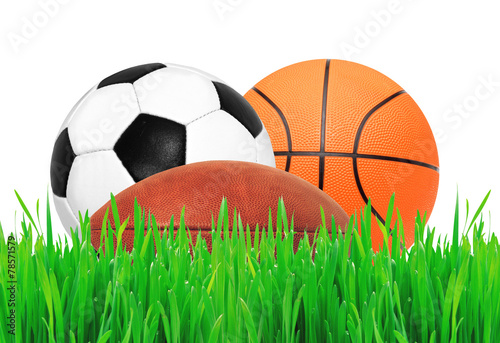 Sports balls on green grass over white