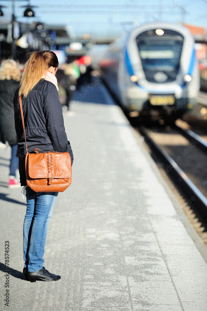 Fototapeta premium Woman waiting for incoming train