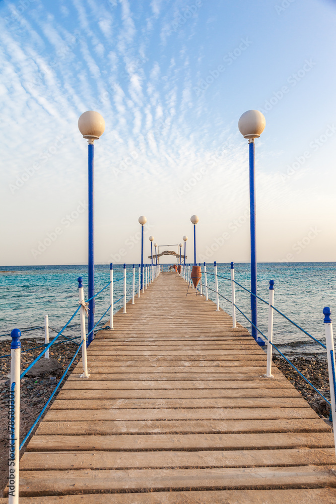 wooden pier leading to open blue sea