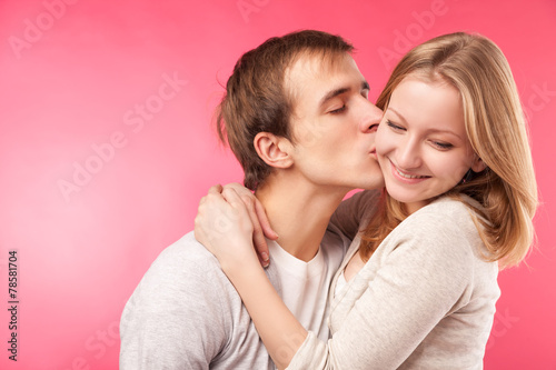 young boy kissing cute girlfriend on cheek.