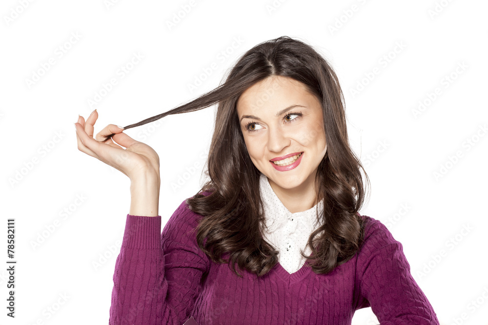 Beautiful happy woman looking at a cowlick of her hair Beautiful happy woman looking at a cowlick of her hair