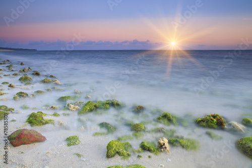 Sunrise on rocky ocean beach