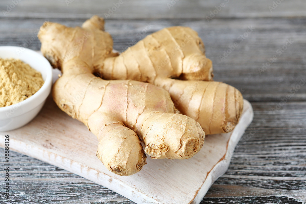 Ginger root on a cutting board with powder