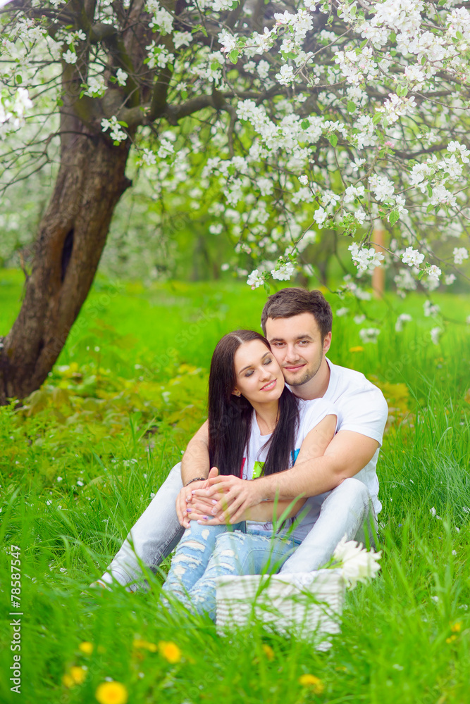 Fototapeta premium happy young couple in the garden with apple flowers