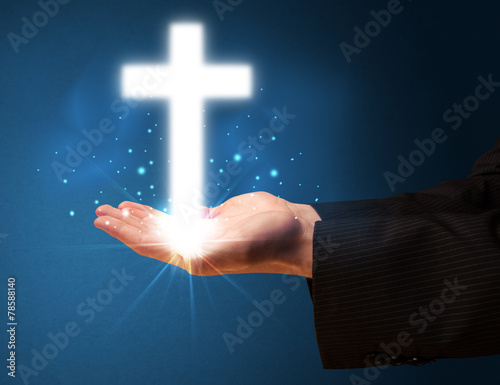 Fototapeta Naklejka Na Ścianę i Meble -  Glowing cross in the hand of a businessman
