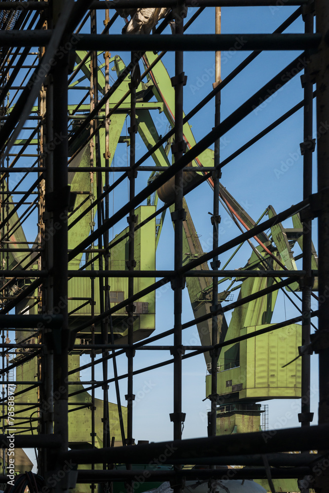 View of the shipyard cranes by scaffolding.