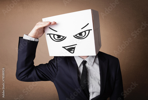 Businessman gesturing with a cardboard box on his head with evil