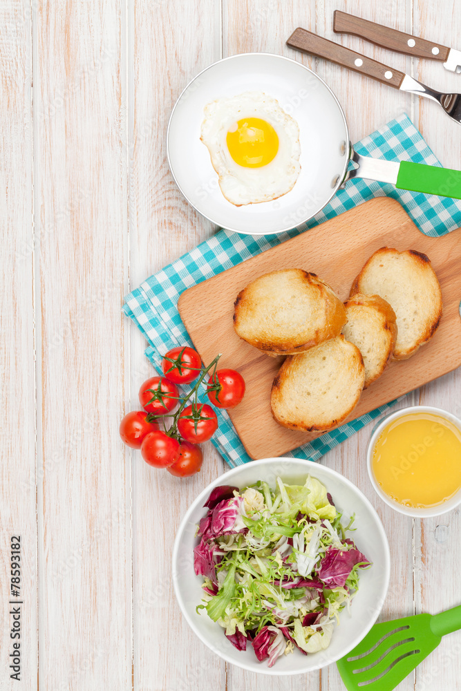 Healthy breakfast with fried egg, toasts and salad