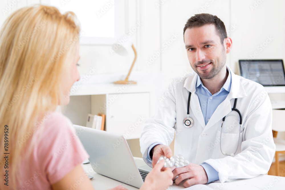 Young attractive doctor giving pills to a patient Young attractive doctor giving pills to a patient