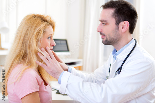 Young attractive doctor analysing blonde patient face