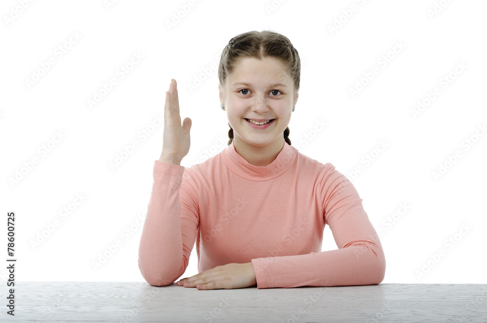 Little girl at the table in school on white
