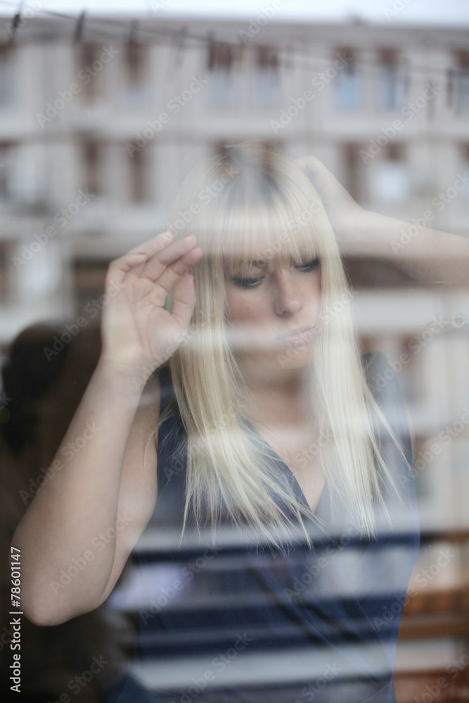 Fototapeta premium Portrait of beautiful blonde through the glass