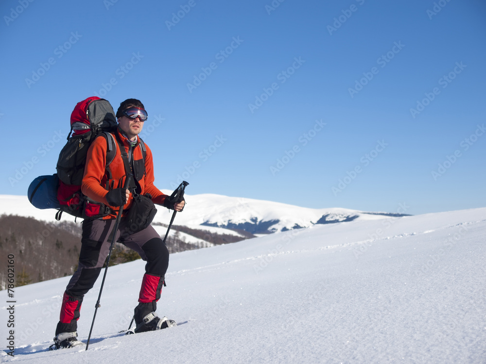 The man in snowshoes in the mountains. The man in snowshoes in the mountains.