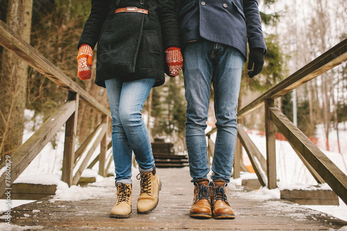 Couple holding hands standing in a winter forest straight