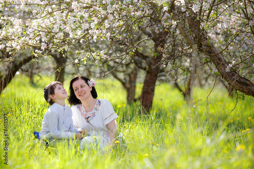 Happy woman and child in spring apple garden
