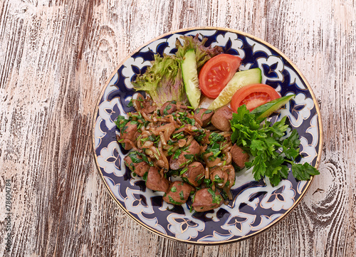 Fried meat with onion in a frying pan