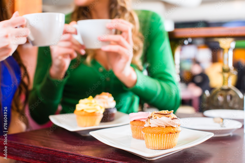 Frauen essen Muffins beim Kaffee trinken Frauen essen Muffins beim Kaffee trinken