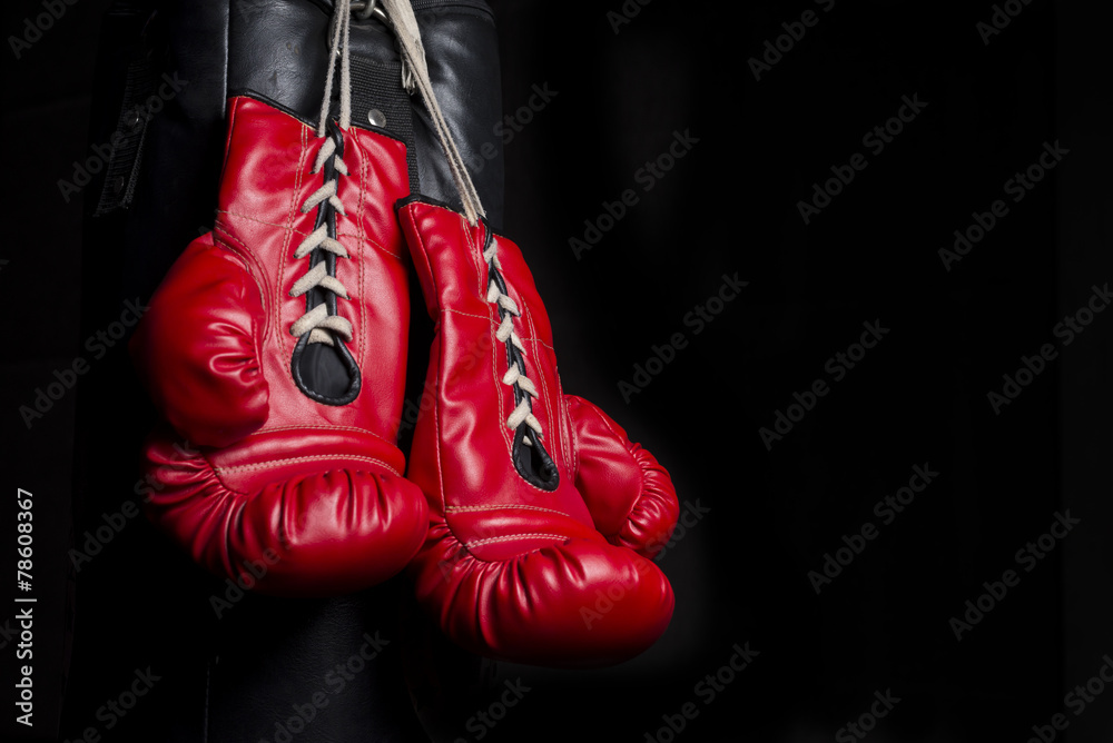 A pair of red boxing gloves with low key lighting
